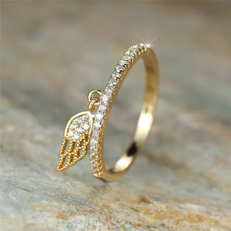 Ring with gold angel wings pendant