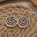 Dangling earrings with chiseled spiral