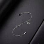 Gold bracelet with small silver spiral charm