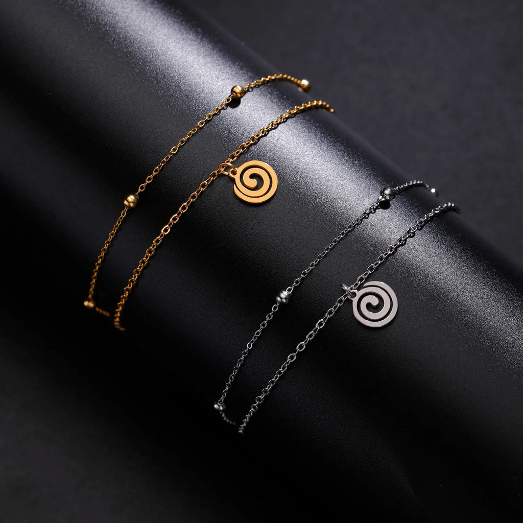 Gold bracelet with small silver spiral charm