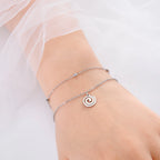 Gold bracelet with small silver spiral charm
