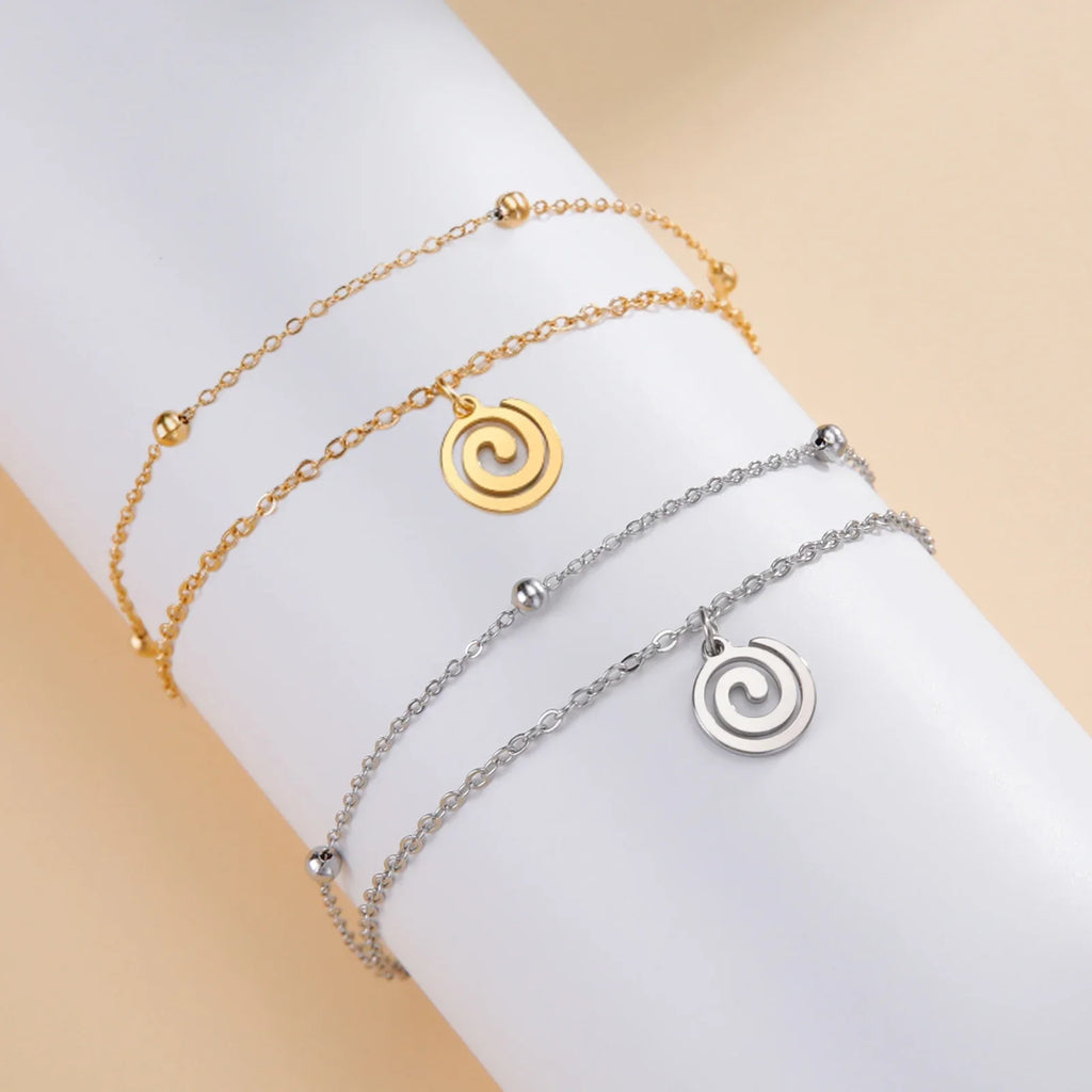 Gold bracelet with small gold spiral charm
