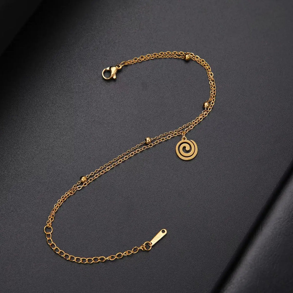 Gold bracelet with small gold spiral charm