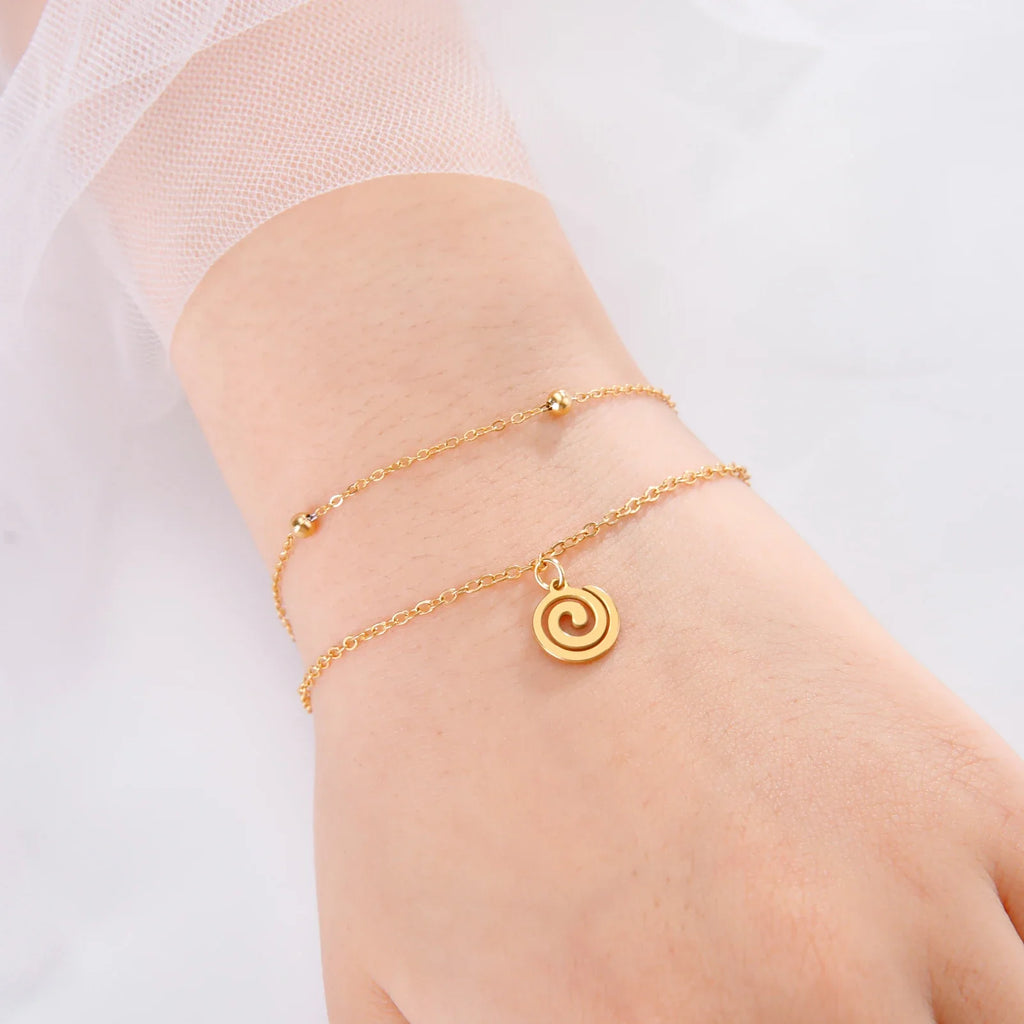 Gold bracelet with small gold spiral charm