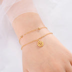 Gold bracelet with small gold spiral charm