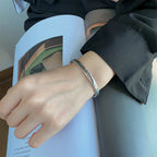 Open bangle bracelet with silver feather