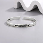 Open bangle bracelet with silver feather