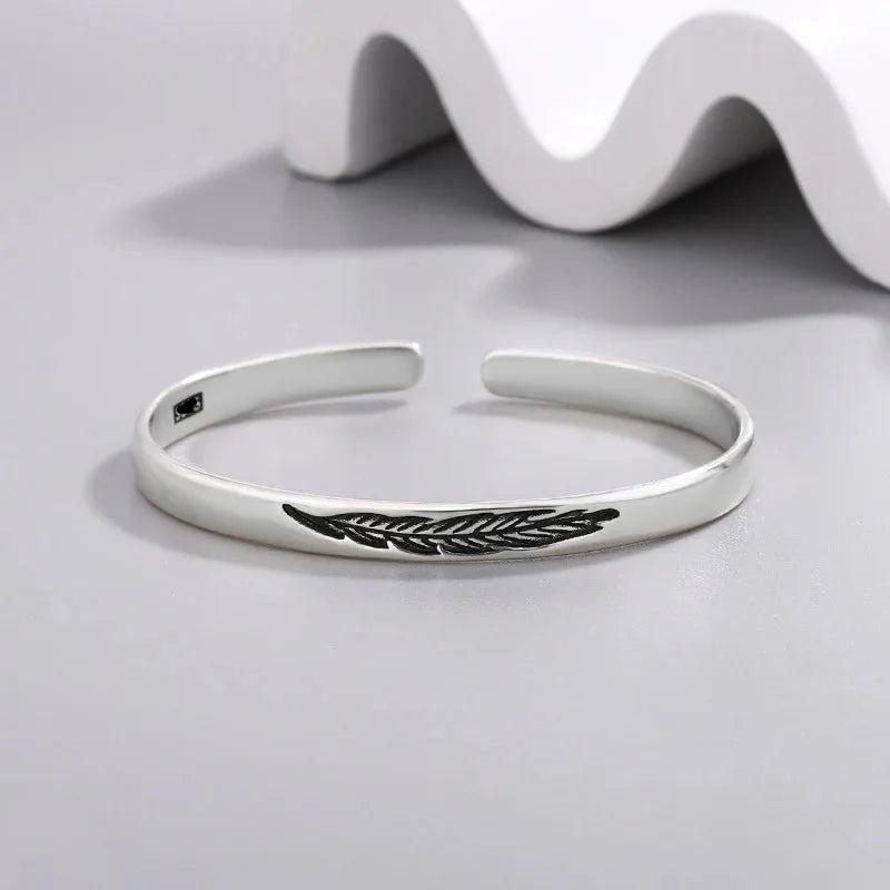 Open bangle bracelet with silver feather
