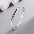 Open bangle bracelet with silver feather