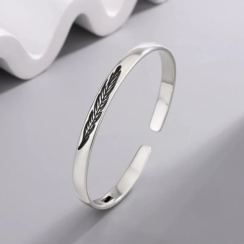 Open bangle bracelet with silver feather