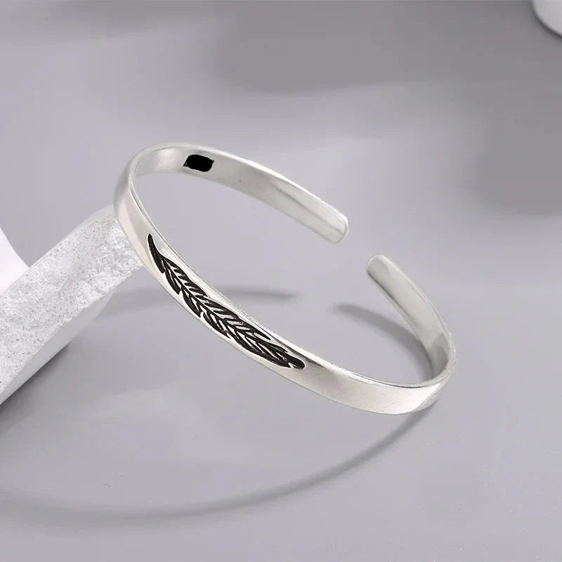 Open bangle bracelet with silver feather