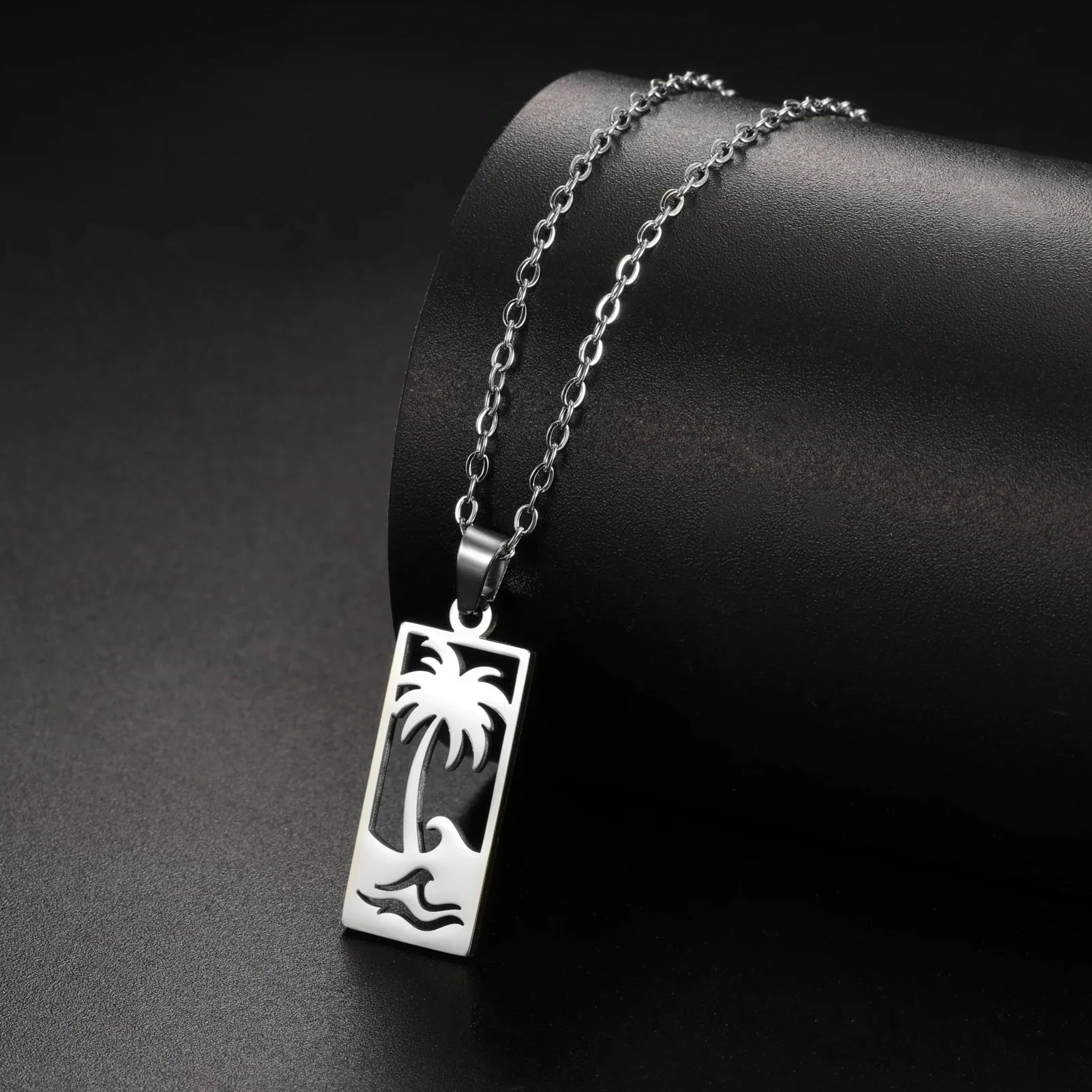 Necklace with palm tree and beach wave pendant in silver