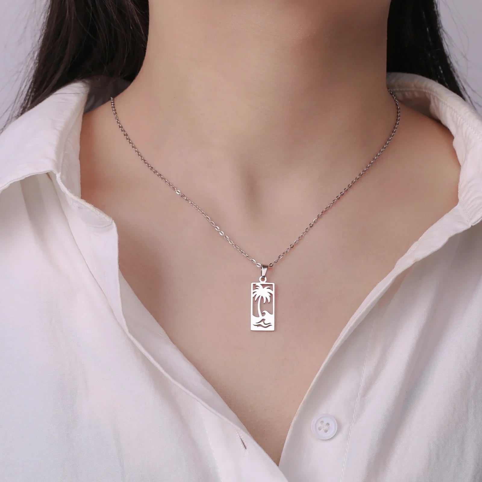 Necklace with palm tree and beach wave pendant in silver