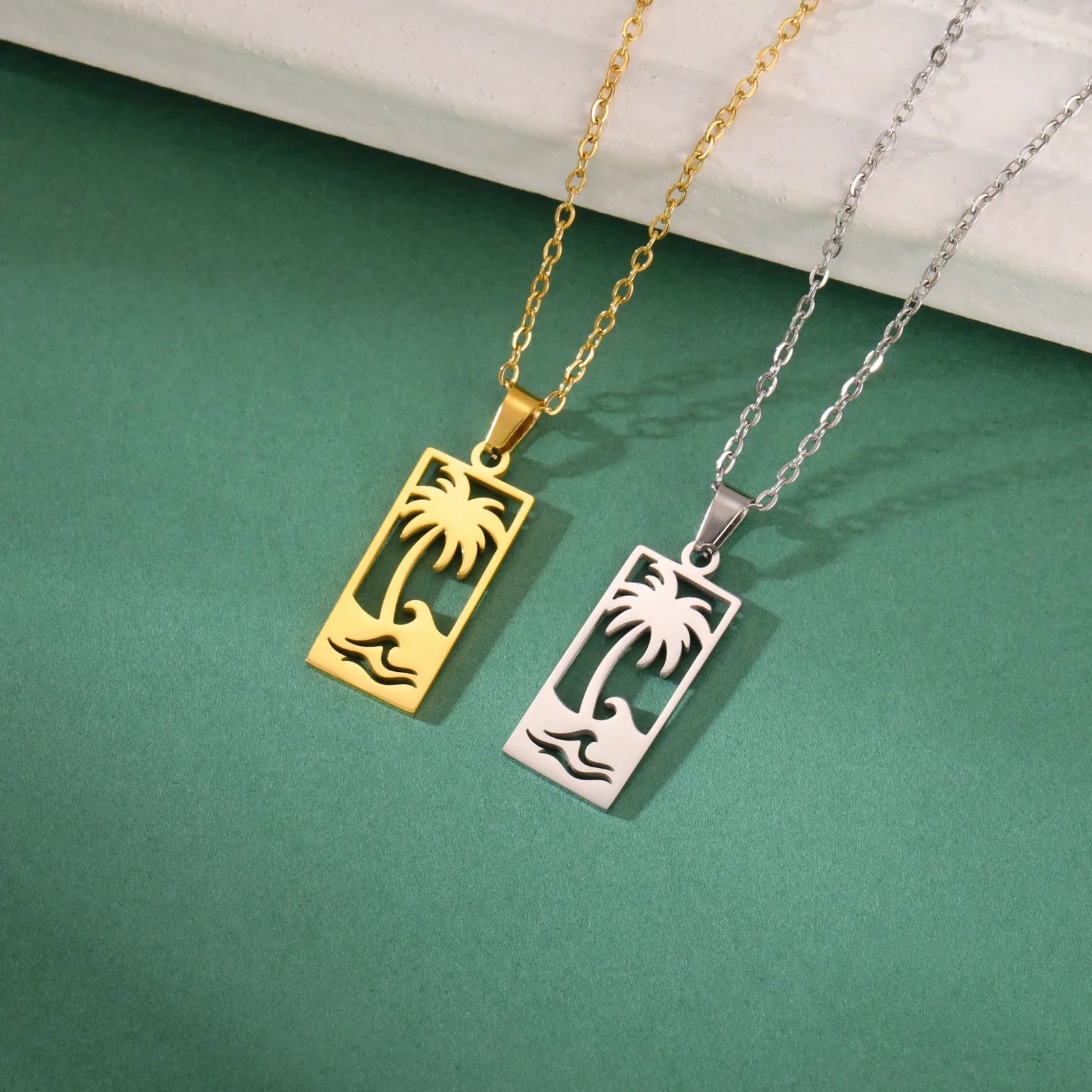 Necklace with palm tree and beach wave pendant in gold