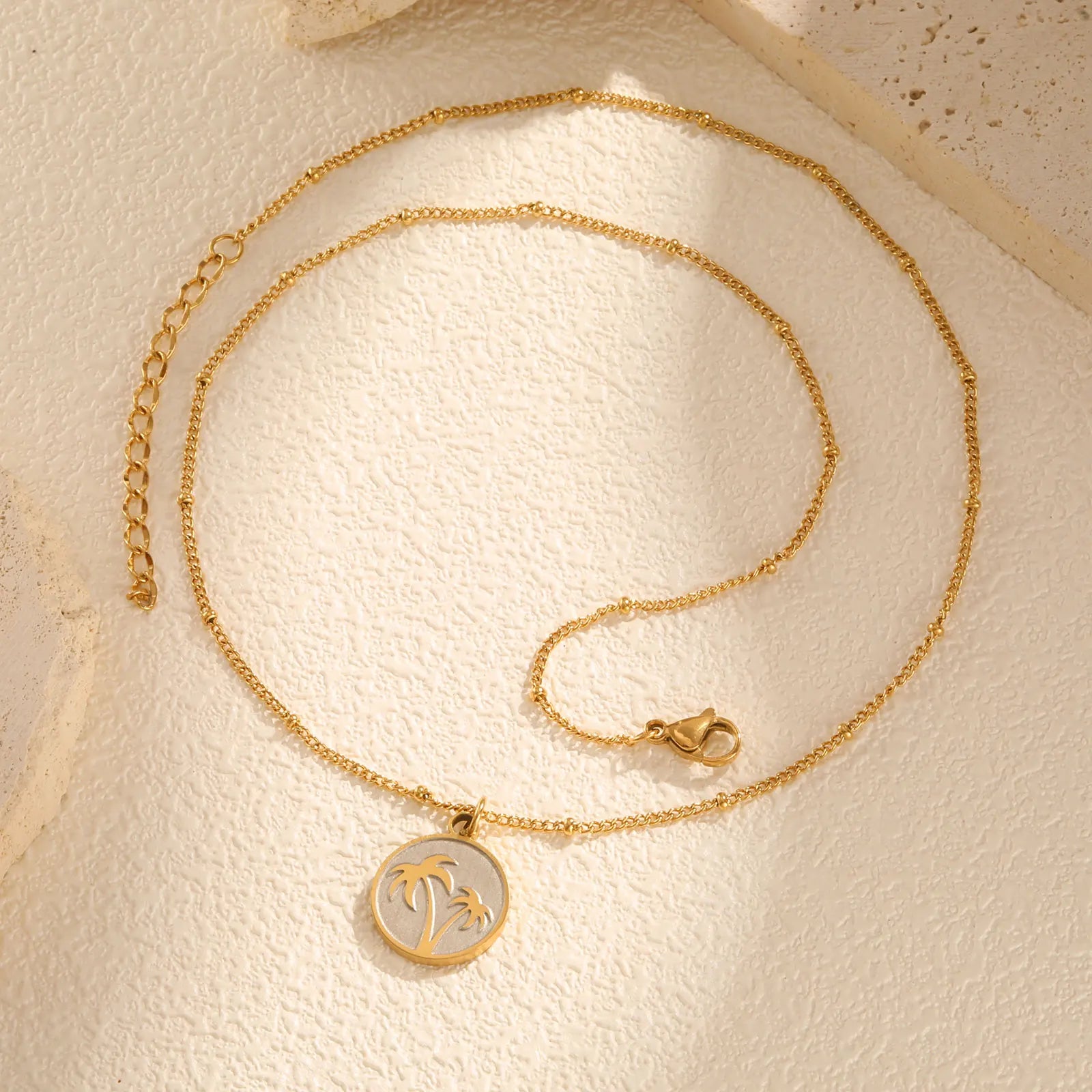 Necklace with round pendant and palm tree motif