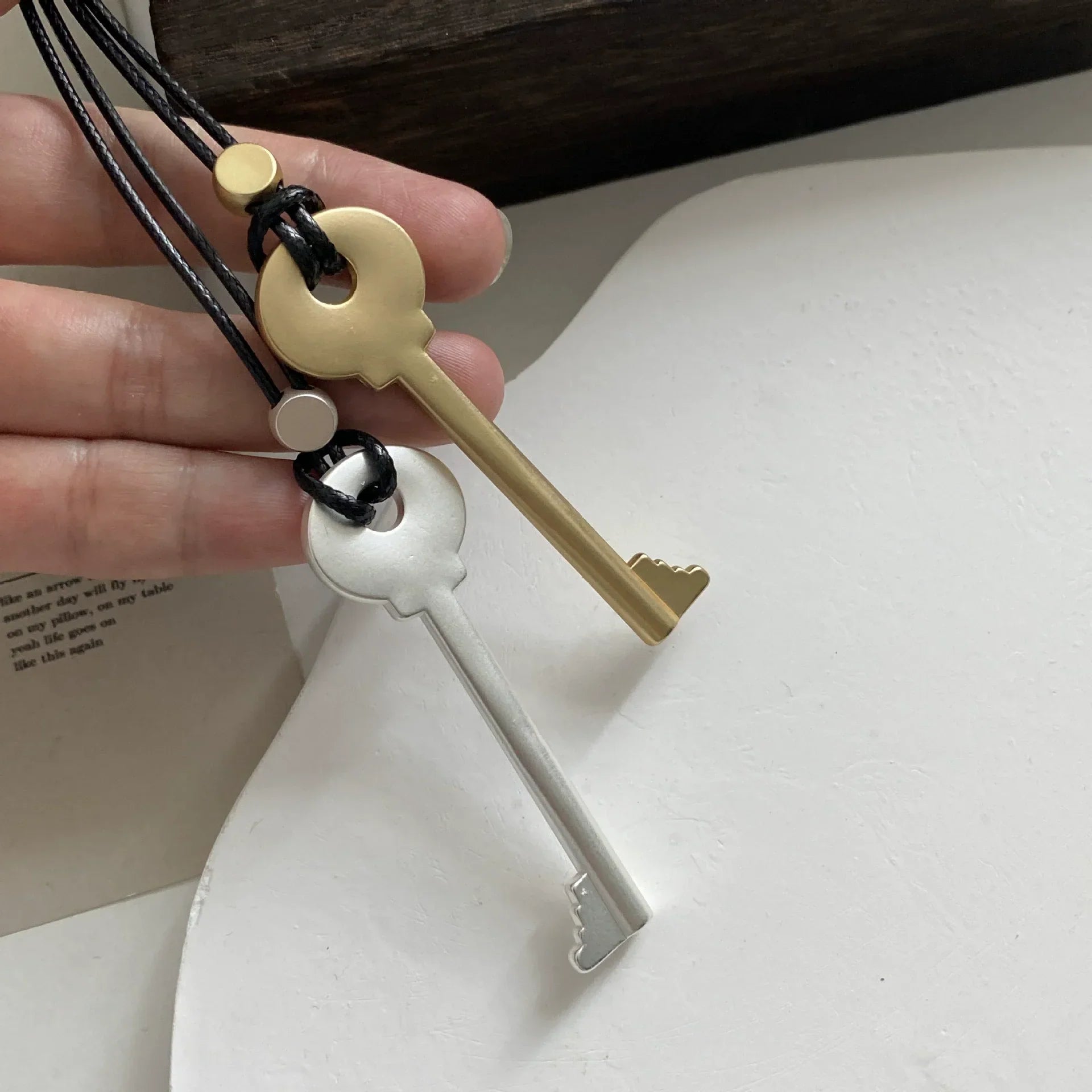 Long rope necklace with matte silver key pendant