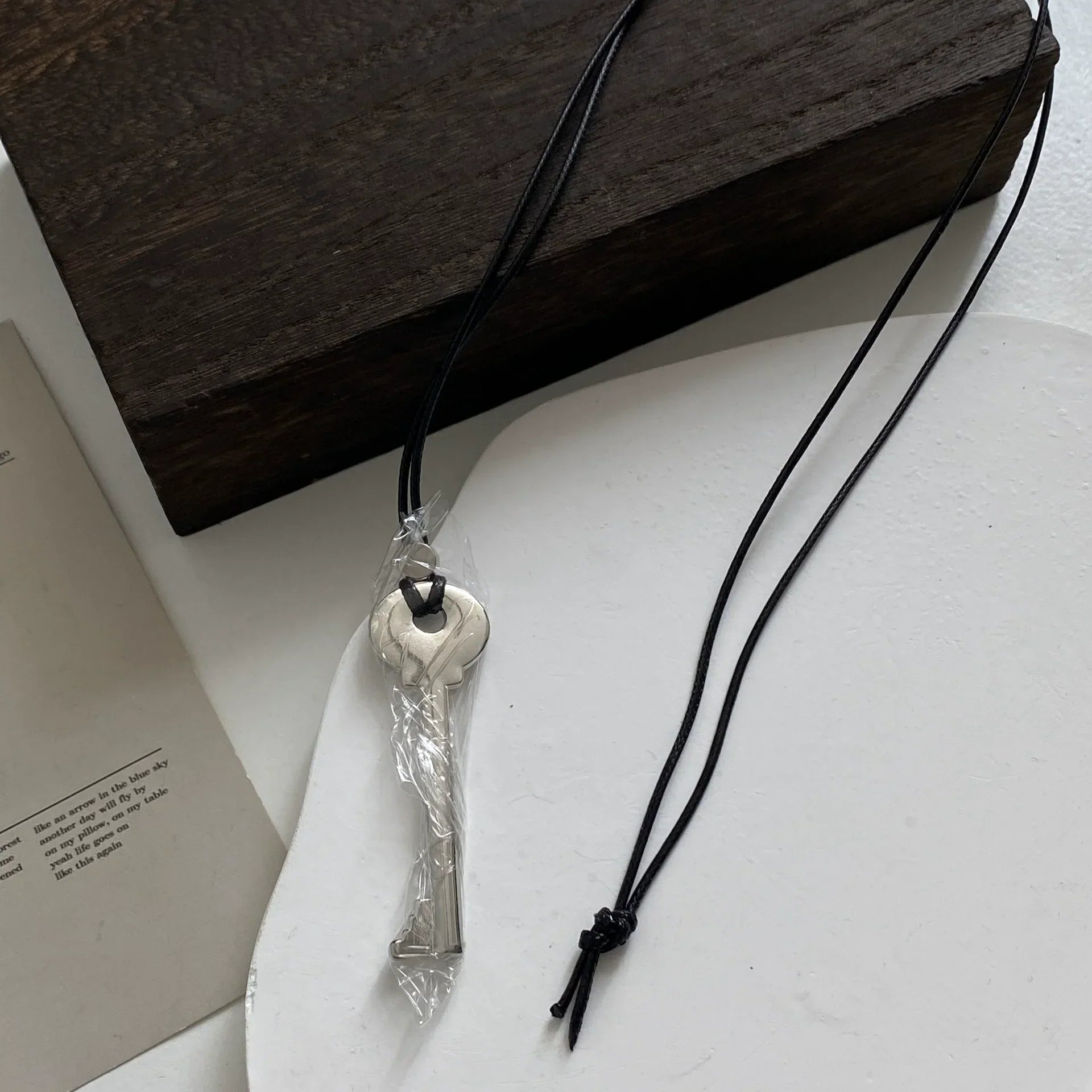 Long rope necklace with shiny silver key pendant
