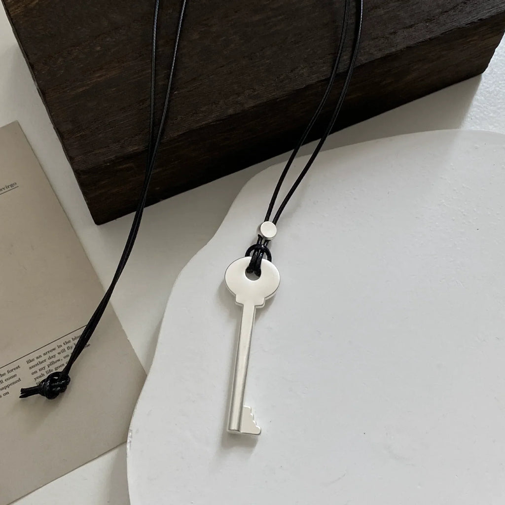 Long rope necklace with matte silver key pendant