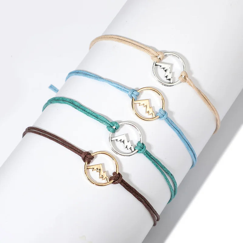 Set of 4 Cord Bracelets with Round Mountain Pendant